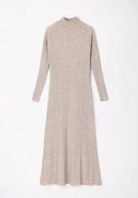 Robe longue côtelée de couleur beige clair, avec un col montant et des manches longues. Le tissu a une texture douce et tombe librement au niveau de l'ourlet.