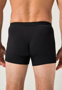 Czarne bokserki wykonane z gładkiego materiału, z szerokim pasem z nazwą marki 'JP1880' w subtelnych literach.