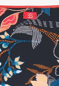 Tissu noir avec des motifs floraux et de feuilles colorés en orange, bleu et rose. Comprend une petite étiquette rouge avec un logo blanc.