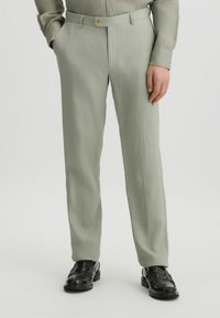 Helle grüne, leichte Stoffhosen mit geradem Schnitt, ausgestattet mit einem Knopfverschluss und Seitentaschen, kombiniert mit schwarzen Loafers.