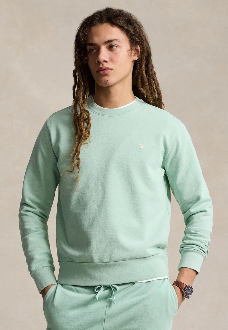Sweatshirt verde menta em mistura de algodão, com decote redondo, punhos e barra canelados, e um pequeno detalhe de logótipo no peito.