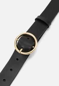 Black leather belt featuring a circular gold-tone buckle, smooth texture, and multiple holes for adjustability.