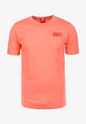 Korallfarbenes T-Shirt mit kurzen Ärmeln und Rundhalsausschnitt, mit kleinem New Balance Logo auf der linken Brust und Größenetikett innen im Kragen.