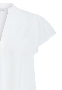 White blouse with flutter sleeves and subtle raised polka dot texture, featuring a V-neckline and a relaxed fit.