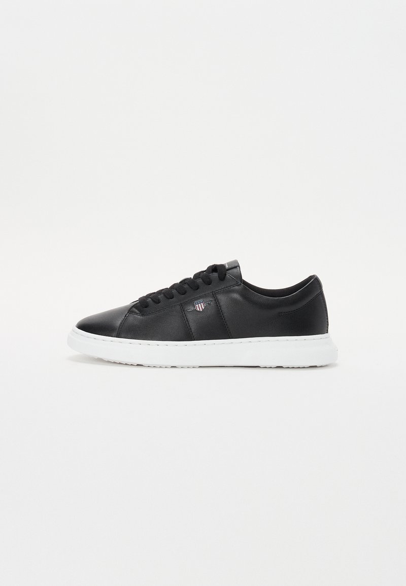Sneaker din piele neagră, cu vârf rotund, design cu șireturi, talpă din cauciuc albă și branding subtil pe lateral. Textură netedă și fără modele vizibile.