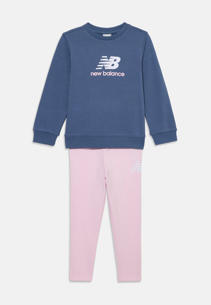 Sweatshirt bleu avec des poignets et un col côtelés, arborant un logo "new balance" blanc ; associé à un legging rose clair affichant un logo.