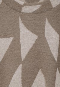 Beige pletený svetr s velkými, abstraktními hnědými tvary. Měkká textura s kulatým výstřihem a ležérním designem.