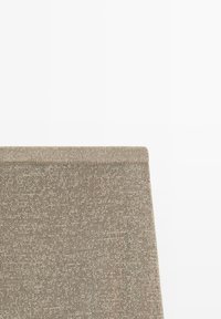 Tissu tricoté beige avec une texture étroitement tissée et un bord fini plié en haut sur un fond blanc uni.
