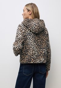 Faux fur-jacka med leopardmönster i beige och brunt, med huva, varm textur och cropped design.