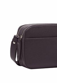 Borsa in pelle viola scuro con una forma strutturata, dotata di doppia cerniera, tracolla regolabile e una tasca anteriore a scomparsa per un facile accesso.