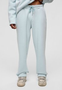 Lichtblauwe sweatpants van zacht materiaal, met een elastische tailleband met trekkoord, zijzakken en een relaxte pasvorm.