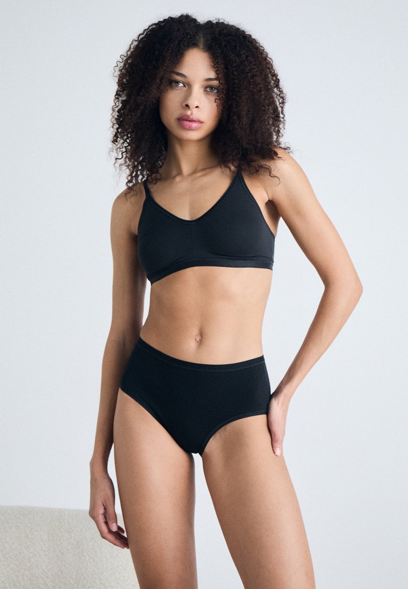 Black bralette and high-waisted brief set made of soft fabric. Features a simple design with adjustable straps and elastic waistband.