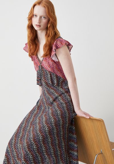 Vestido maxi em estampado preto, vermelho e roxo, com mangas caprichadas e decote em V, apresentando um padrão ondulado e um tecido leve.