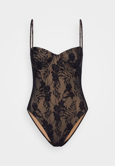 Svart og beige blondedrakt med blomsterdesign, hjerteformet utringning, justerbare stropper og høyt skjærte ben. Teksturert stoffdetalj.