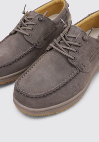 Scarpe in suede grigio con profilo basso, punta rotonda e interno giallo a contrasto. Presentano una chiusura tradizionale con lacci e suola in gomma testurizzata.