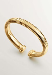 Pulsera de puño en tono dorado con un diseño flexible en espiral y acentos lisos en los extremos. Presenta una textura acanalada en toda su superficie.
