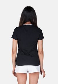 Puma AMPLIFIED - Triko s potiskem - nero