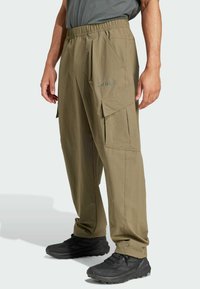 Khaki cargo bukser med elastisk talje, sidelommer og et slankt, letvægtsmateriale. Dækker "TERREX" logo i grå.