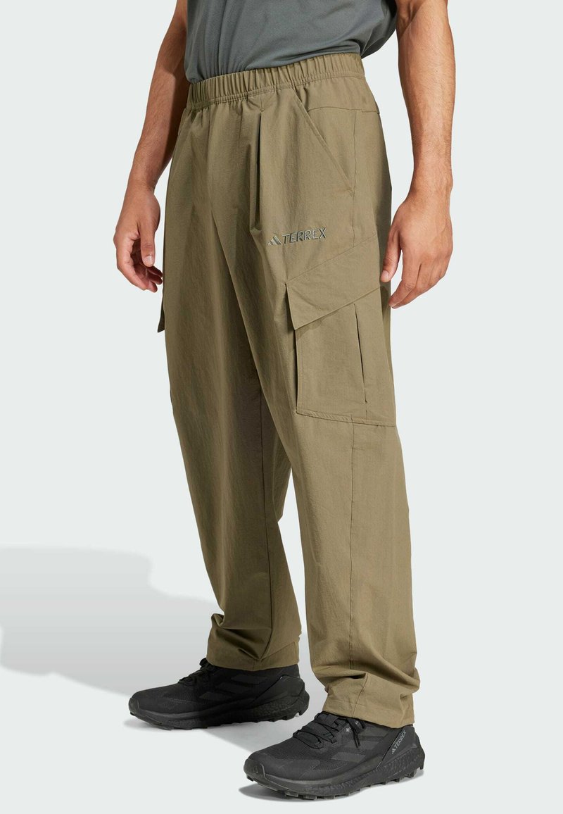 Khaki cargo bukser med elastisk talje, sidelommer og et slankt, letvægtsmateriale. Dækker "TERREX" logo i grå.