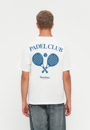 White cotton t-shirt featuring a blue graphic print on the back with "PADEL CLUB" and two padel rackets, along with "Barcelona" text below.