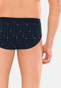 Slip blu navy a quadretti con una vita morbida. Il motivo presenta sfumature variate di blu e grigio in un design a griglia.