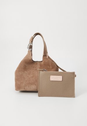 Bolso de ante marrón con asas redondeadas, acompañado de un neceser pequeño de cuero beige con cremallera y etiqueta frontal.