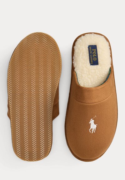 Braune Wildleder-Hausschuhe mit weißem Polo Ralph Lauren-Logo, weichem cremefarbenem Innenfutter und strukturierter Gummisohle, von oben und unten gezeigt.