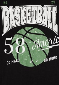 Camiseta negra con texto blanco y verde, un gran gráfico de baloncesto verde y los números "58" y "2024". El texto dice "HAZLO DURO O VETE A CASA."