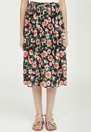 Jupe midi florale mettant en valeur un fond noir avec des fleurs roses et oranges, design plissé et taille élastique. Associée à des sandales en or rose.