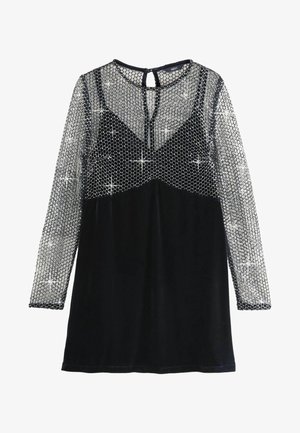 Czarna welurowa sukienka z długimi, przezroczystymi rękawami, błyszcząca warstwa srebrnych cekinów na siatkowym materiale na górnej części klatki piersiowej i ramionach, zapięcie z tyłu na kluczyk.