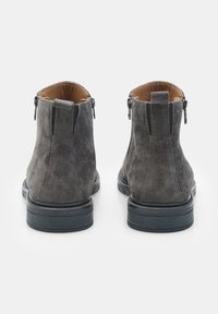 Stivaletti alla caviglia in suede grigio con una superficie liscia, dotati di una suola in gomma nera e zip sul retro per un facile accesso.