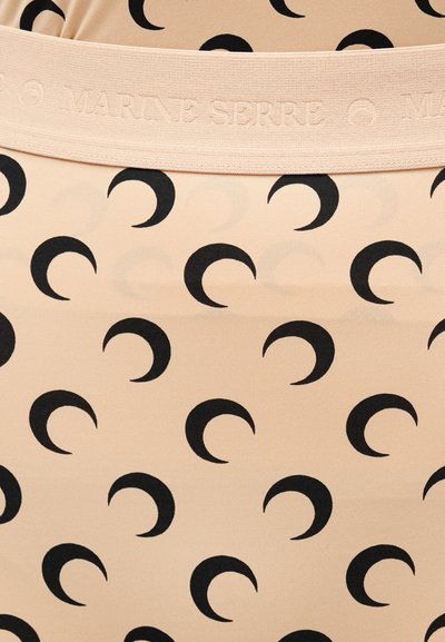 Bež tkanina z ponavljajočim se črnim vzorcem polmeseca in bež elastičnim pasom z vtisnjenim napisom »Marine Serre«.