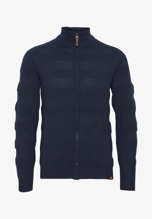 Marine gebreide trui met een hoge kraag, een ritssluiting aan de voorkant, geribde manchetten en gestructureerde horizontale patronen in de stof.