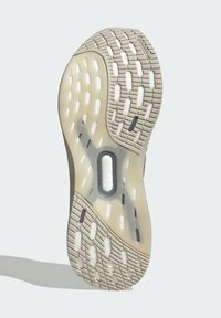 Suela de zapato con banda de goma beige, acolchado blanco visible a través de secciones transparentes y etiqueta "SISTEMA TORSION" cerca del centro.