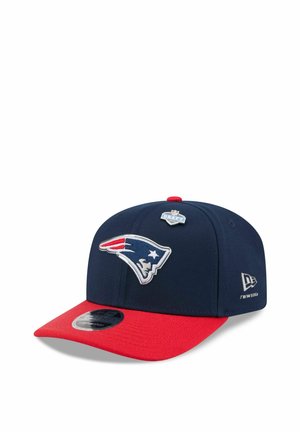 Navy blue and red snapback cap featuring the New England Patriots logo and an NFL Draft 2023 pin on the front panel.