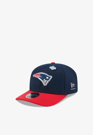 Navy blue and red snapback cap featuring the New England Patriots logo and an NFL Draft 2023 pin on the front panel.