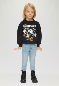 Zwarte sweatshirt met geesten- en pompoenprint, lichtblauwe spijkerbroek en zwarte laarzen. Eenvoudig ontwerp, casual pasvorm, geschikt voor kinderen.