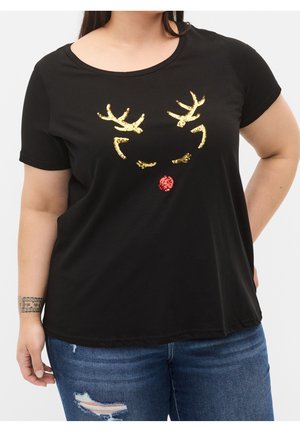 Nainen, joka pukeutunut mustaan t-paitaan, jossa on kultaiset paljettiporo- ja ripsikoristeet sekä punainen paljettinen nenä, yhdistettynä revittyihin sinisiin farkkuihin.