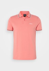 Polo shirt rose clair en coton. Présente un col classique, une patte de boutonnage à trois boutons et des détails rayés sur le col et les manches.