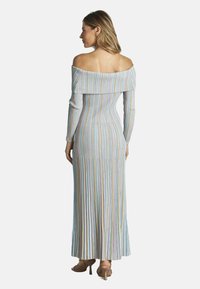 Schulterfreies, langes, geripptes Kleid in pastellfarbenen Streifen, figurbetonte Silhouette, bodenlang, strukturiertes Gewebe, flache Sandalen.