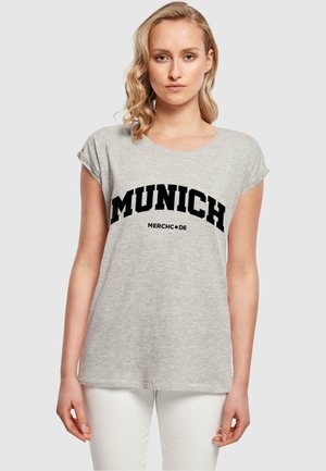 Grå kortermet T-skjorte med rund hals, med fet svart tekst "MUNICH" og "MERCHCODE" sentrert på forsiden.