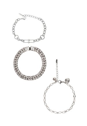 Trzy srebrne bransoletki: łańcuszek z ogniw, masywny łańcuszek z zapięciem oraz delikatny łańcuszek z zawieszkami, prezentujące różnorodne faktury i wzory.