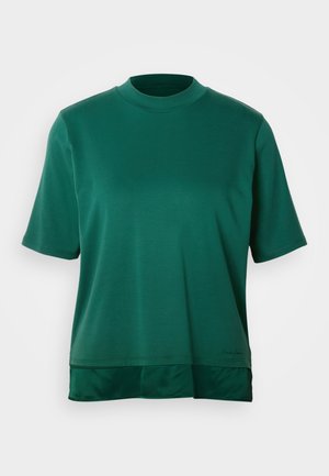Grön kortärmad topp i mjukt tyg, med hög krage och lagerdesign i nederkant. Inga synliga mönster eller hårdvarudetaljer.