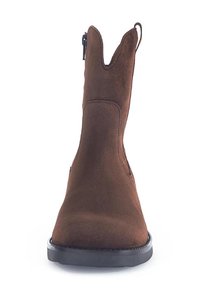 Bottine en suédine marron avec un bout pointu, des panneaux latéraux élastiques et un petit talon empilé. Présente une texture lisse et un design minimaliste.