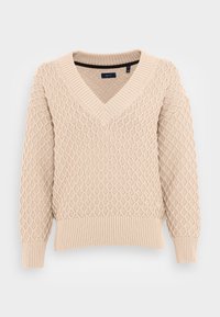 Maglione lavorato a maglia beige con scollo a V e motivo a rombi, con polsini e orlo a costine, esposto su uno sfondo bianco uniforme.
