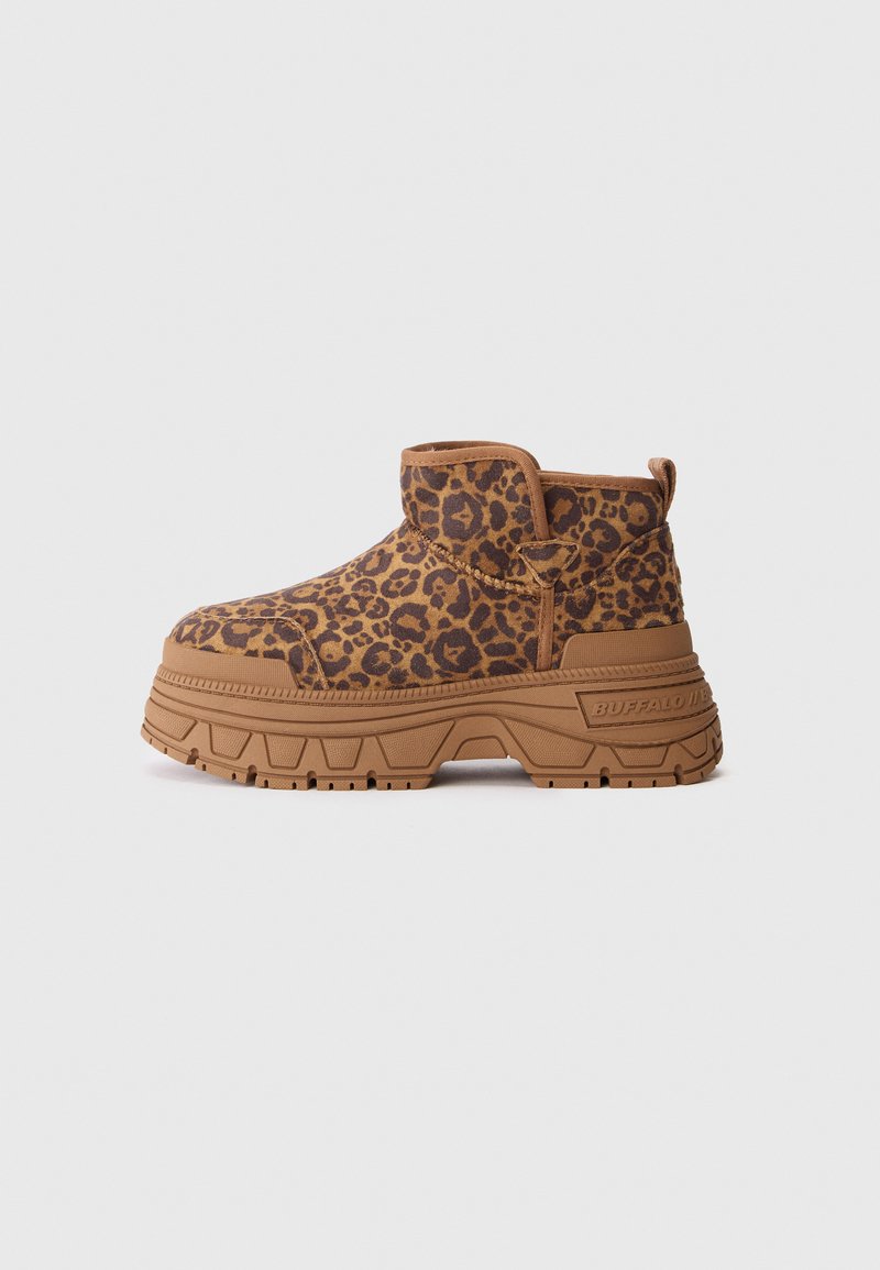 Botín de plataforma con parte superior de estampado de leopardo marrón y negro y suela gruesa color beige sobre fondo blanco.