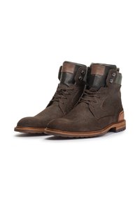Botas de tobillo de ante marrón con un acabado texturizado, acentos de cuero y suela marrón contrastante. Presenta ojales y una etiqueta de cuero con marca.