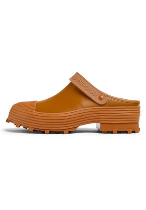 Orangene Gummiclogs mit einem geriffelten Fußbett, verstellbarem Riemen und strukturierten Akzenten. Klobiges Design mit ausgeprägten Traktionsnoppen auf der Sohle.