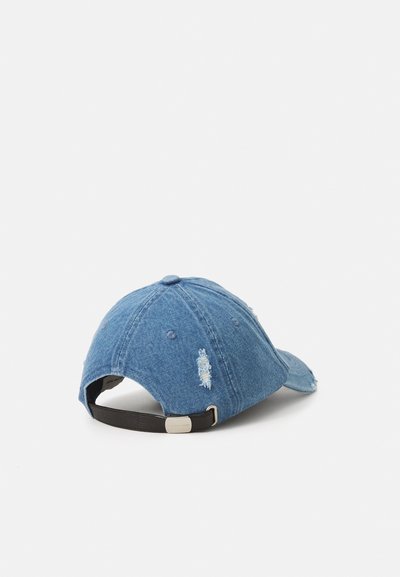 Cappellino da baseball in denim di colore blu chiaro con dettagli distrutti. Presenta una visiera curvata e una cinturino regolabile nero sul retro.