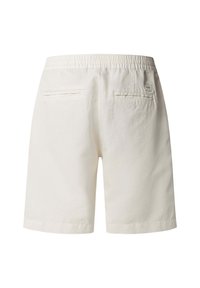 Shorts à taille élastique blanche avec deux poches passepoilées à l'arrière et une petite étiquette logo au-dessus de la poche droite.
